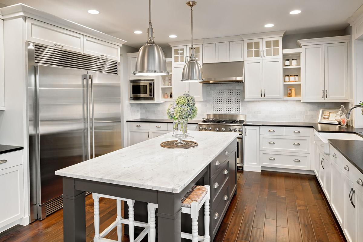 "An inviting kitchen space with a modern, renovated design featuring sleek countertops, stainless steel appliances, and ample storage cabinets."