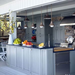 "Image of a beautifully designed and fully equipped outdoor kitchen at a cozy home, featuring modern appliances, spacious countertops, and a charming dining area."