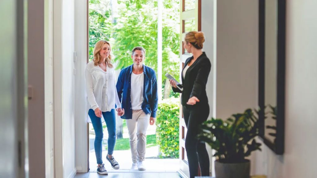 Realtor discussing home sale with a happy couple